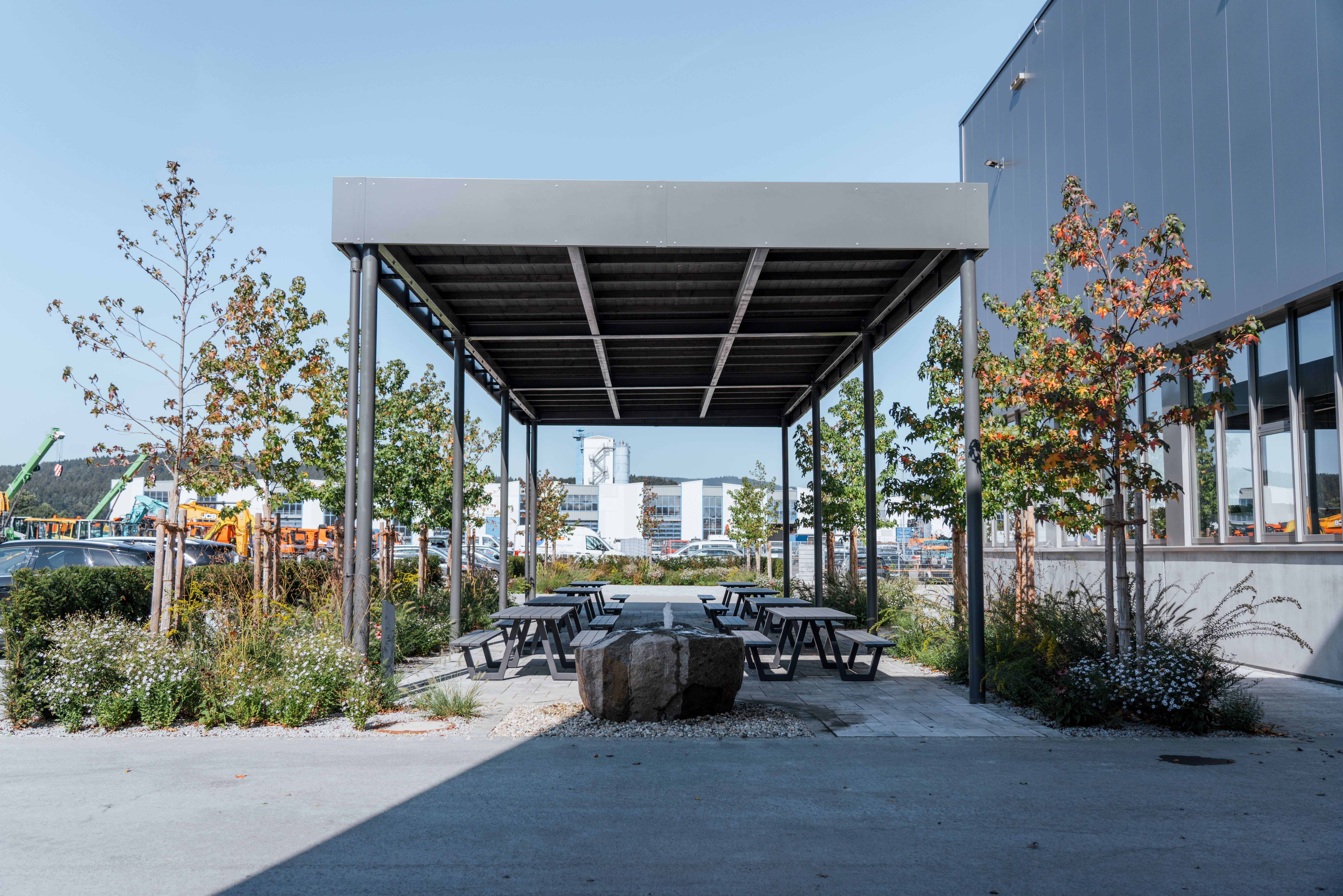 Sitzmöglichkeiten im Außenbereich des Werkstatt- und Logistikzentrums in Weiding, im Hintergrund die Lagerhallen