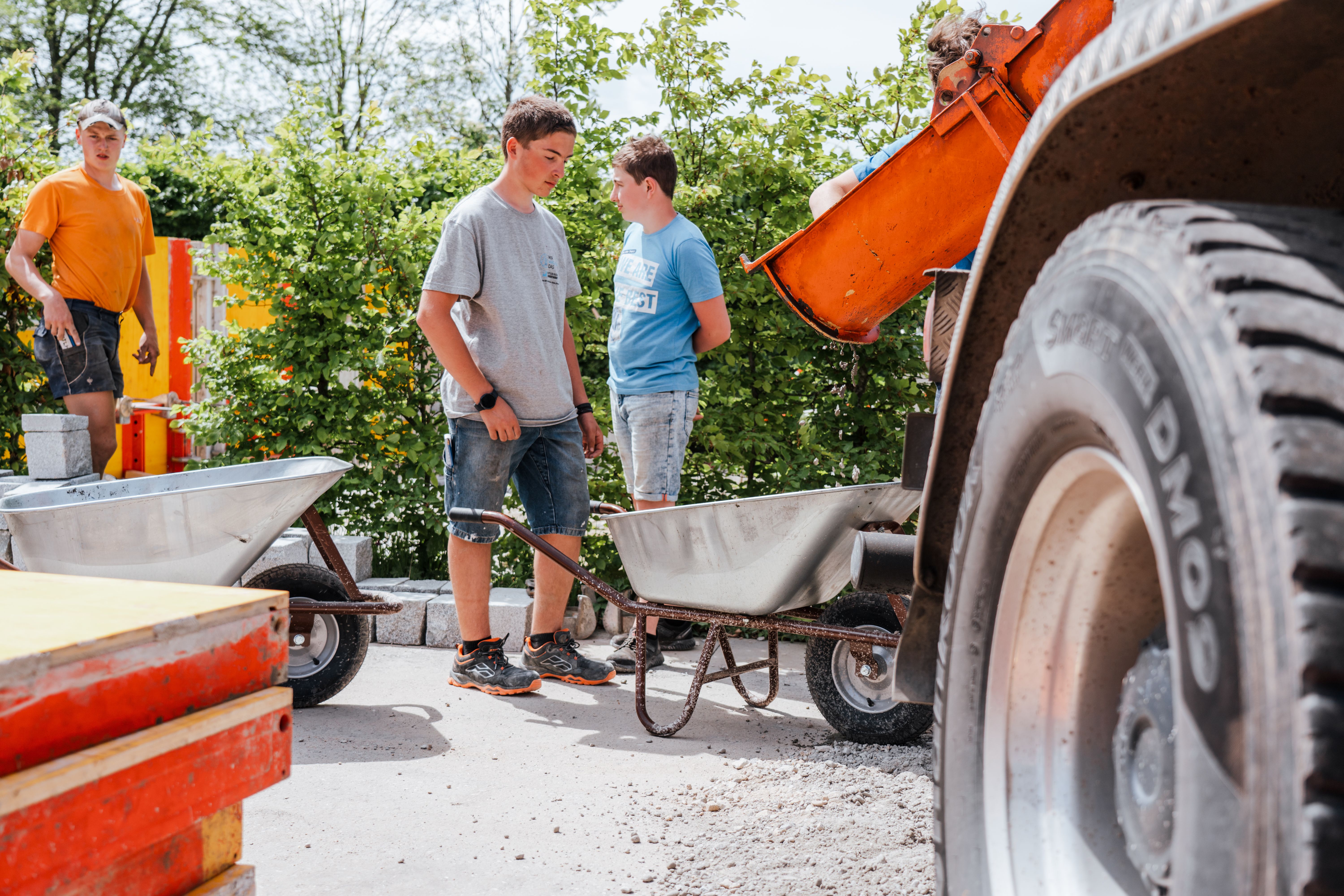 Der frisch gemischte Beton wird mit Schubkarren zu den Schalungen gefahren.