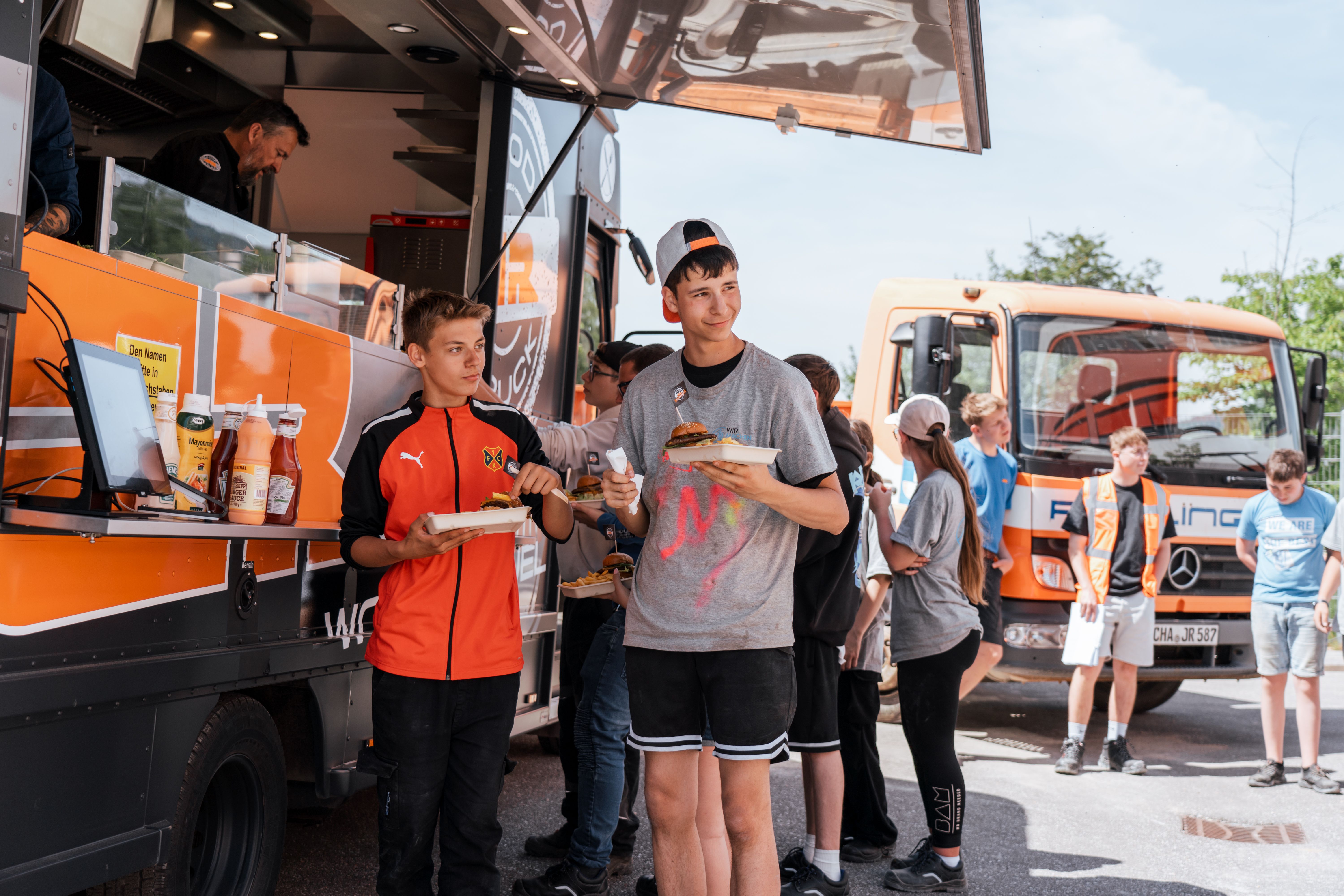 Die Schülerinnen und Schüler holen sich ihr verdientes Essen vom JR Foodtruck ab