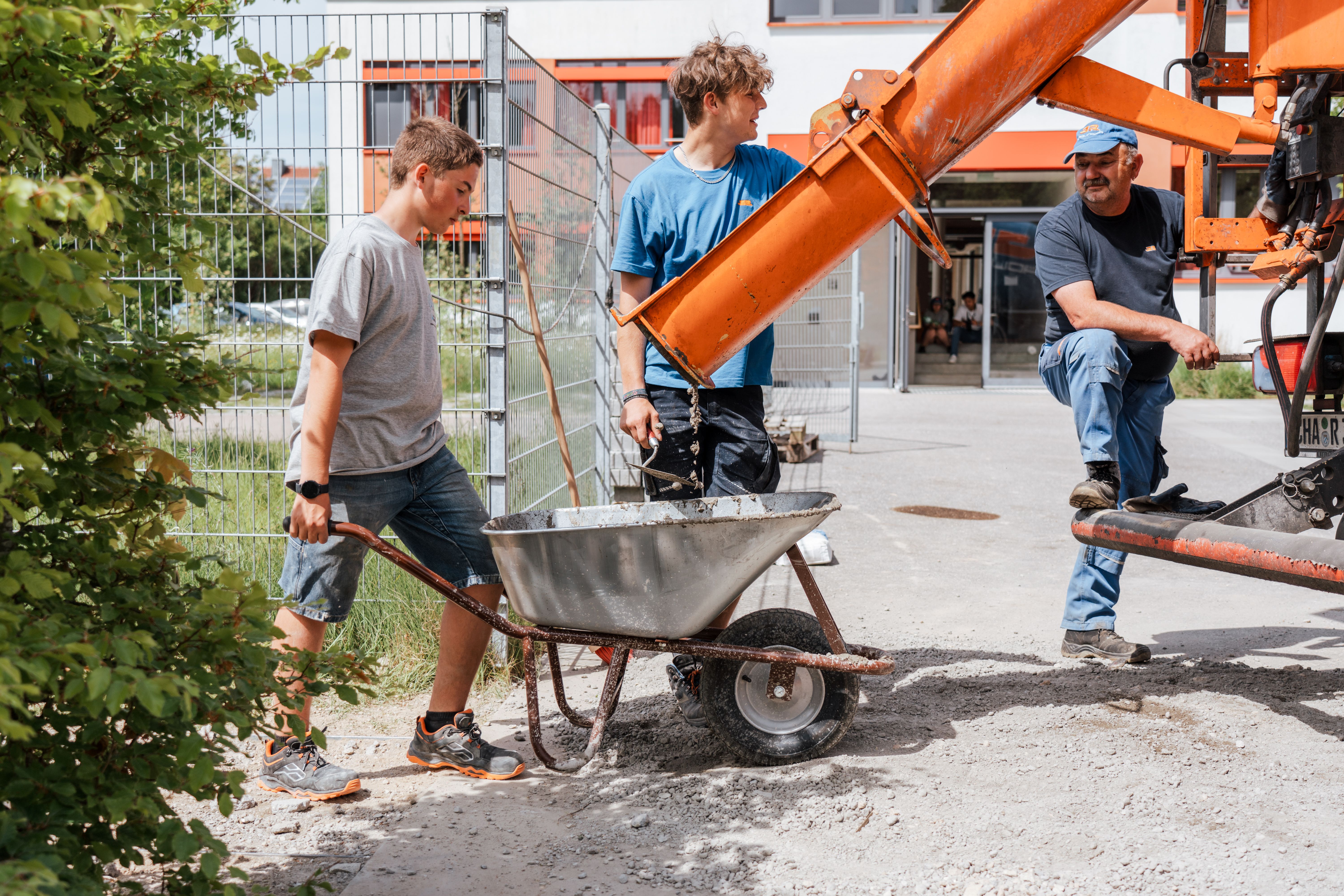 Eine Ladung Beton kommt aus dem Mischer direkt in den Schubkarren.