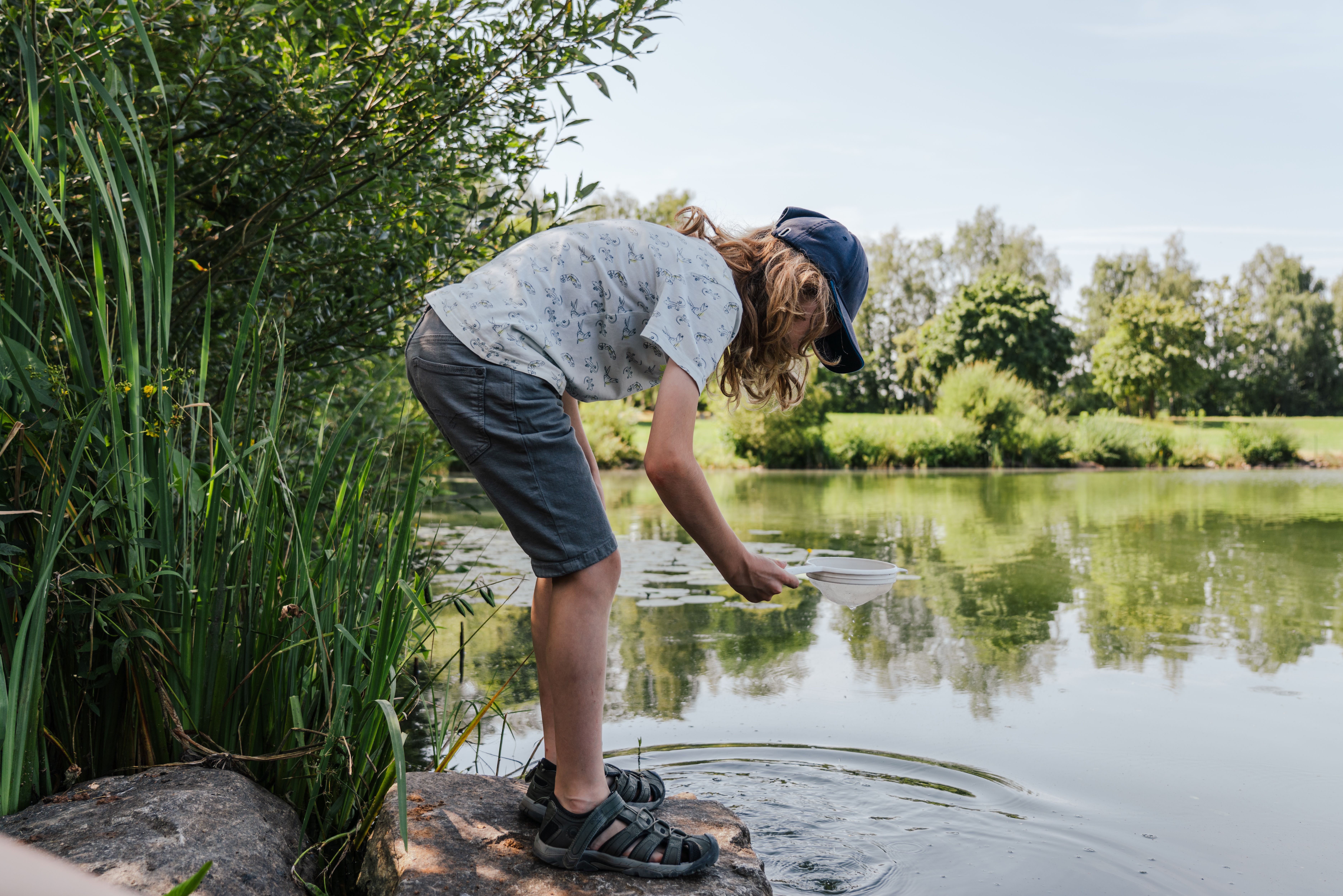 Kind am Ufer des Satzdorfer Sees mit Kescher