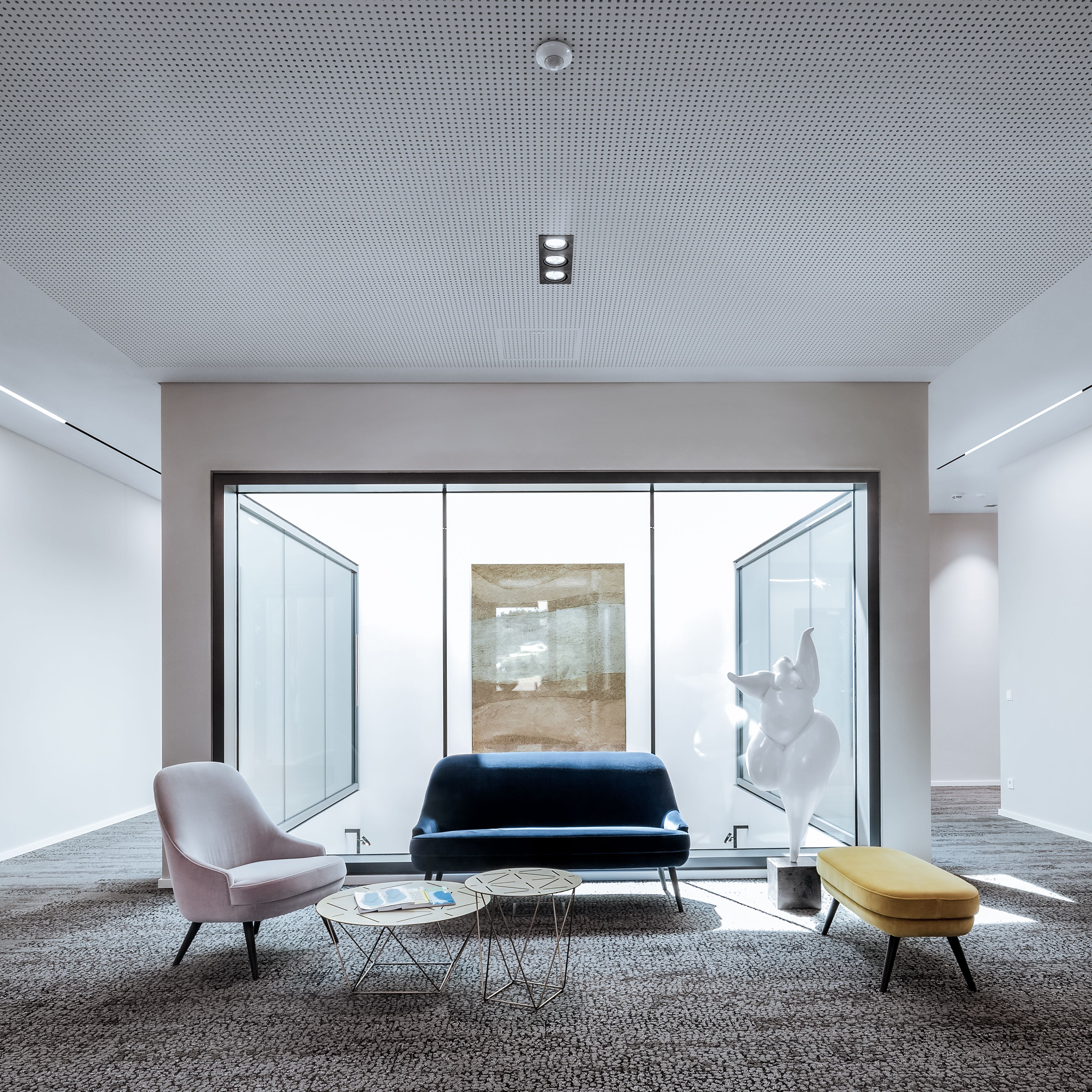 Moderne Sitzgruppe mit Couch und Sessel in der Rädlinger Hauptverwaltung in Cham, daneben eine Kunststatue