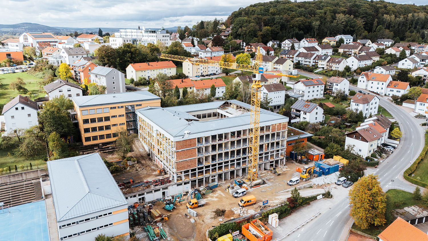 Dohnenaufnahme des entkernten Robert-Schuman-Gymnasiums mit Baufahrzeugen und Baukran
