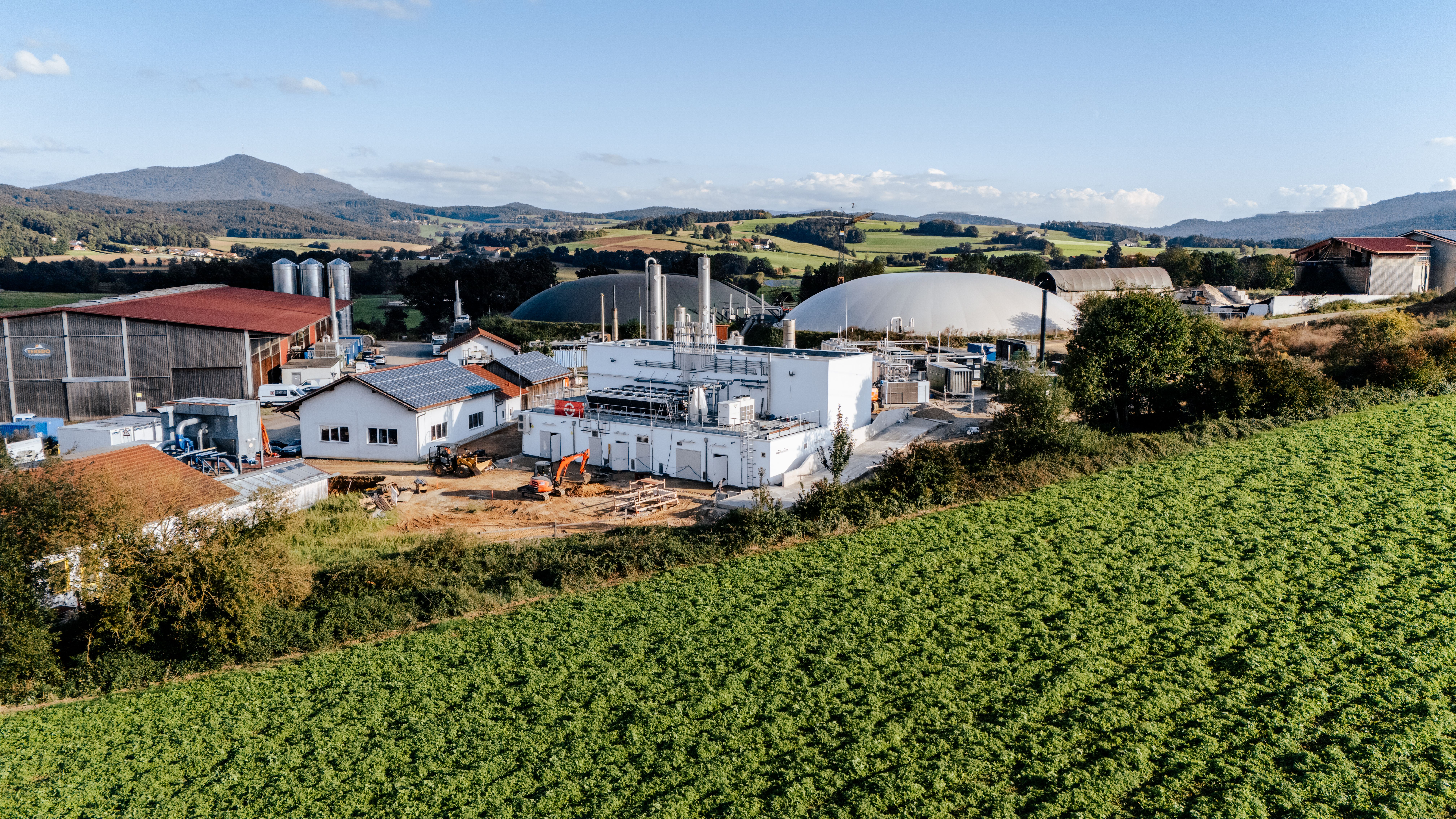 Panoramaaufnahme der Biogasanlage Arnschwang mit einer grünen Wiese im Vordergrund