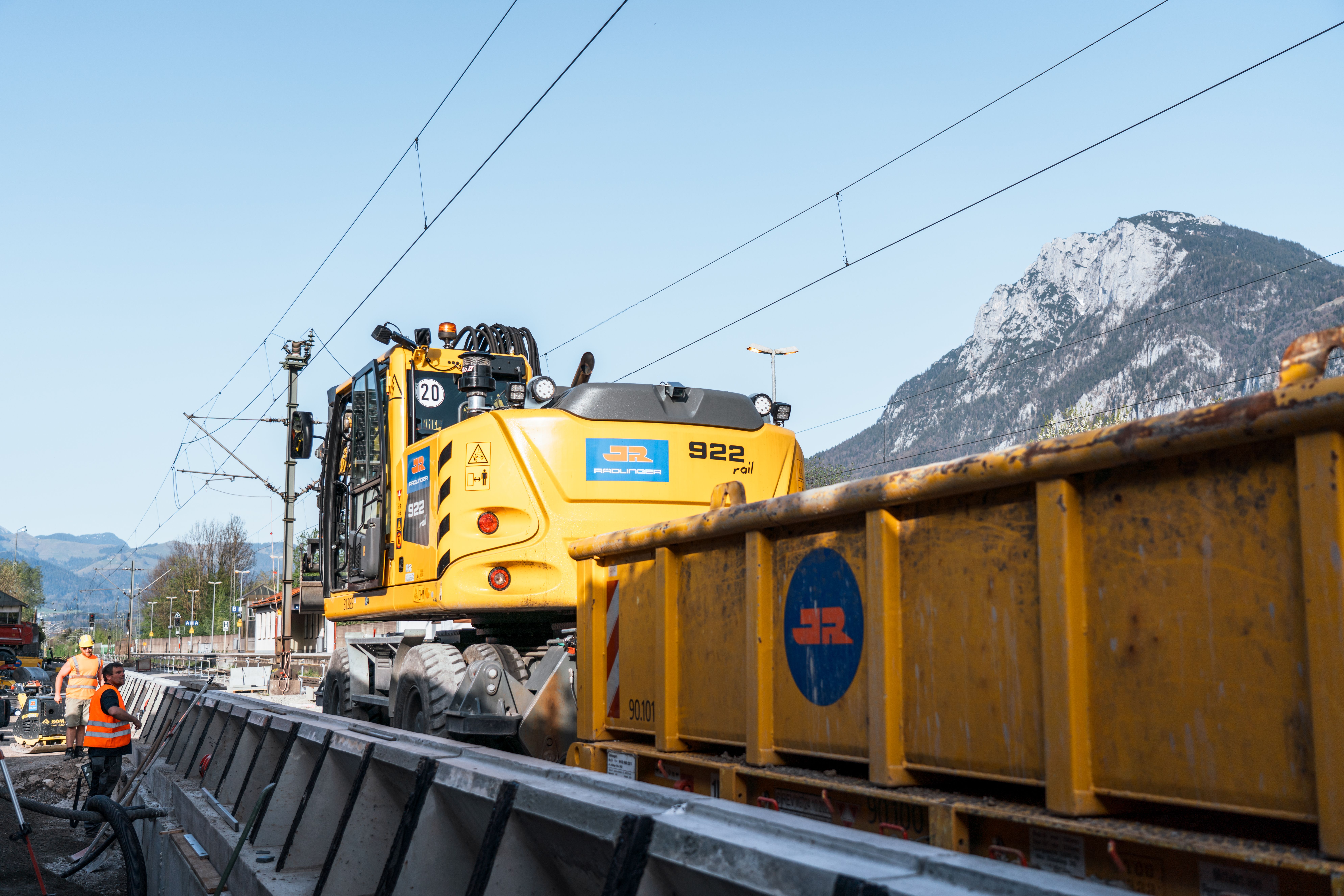JR Bauschuttcontainer wird vom Zweiwegebagger auf den Gleisen gezogen