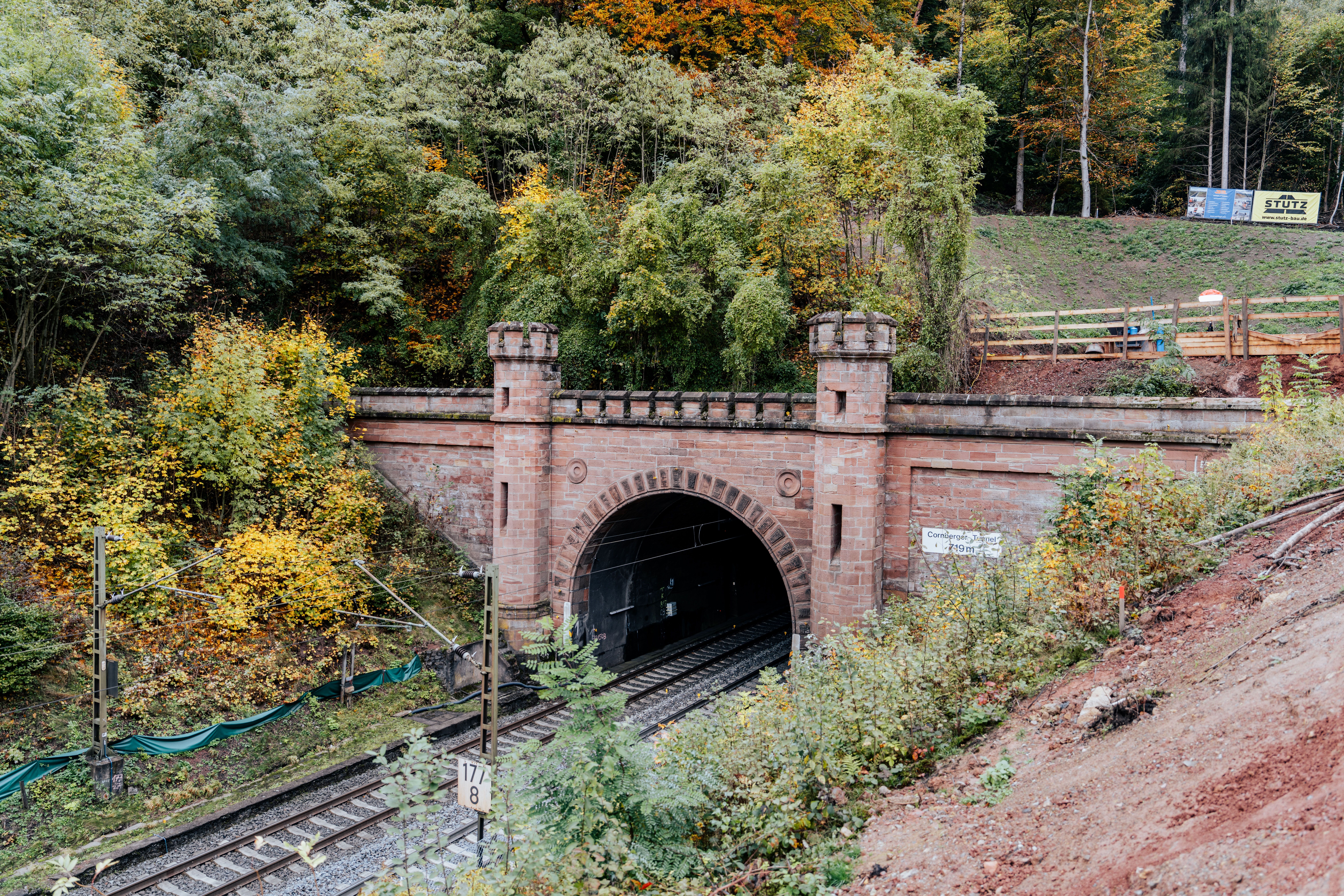 Fronaufnahme des Cornberger Tunnels von vorne im Herbst mit Gleisen und Oberleitung