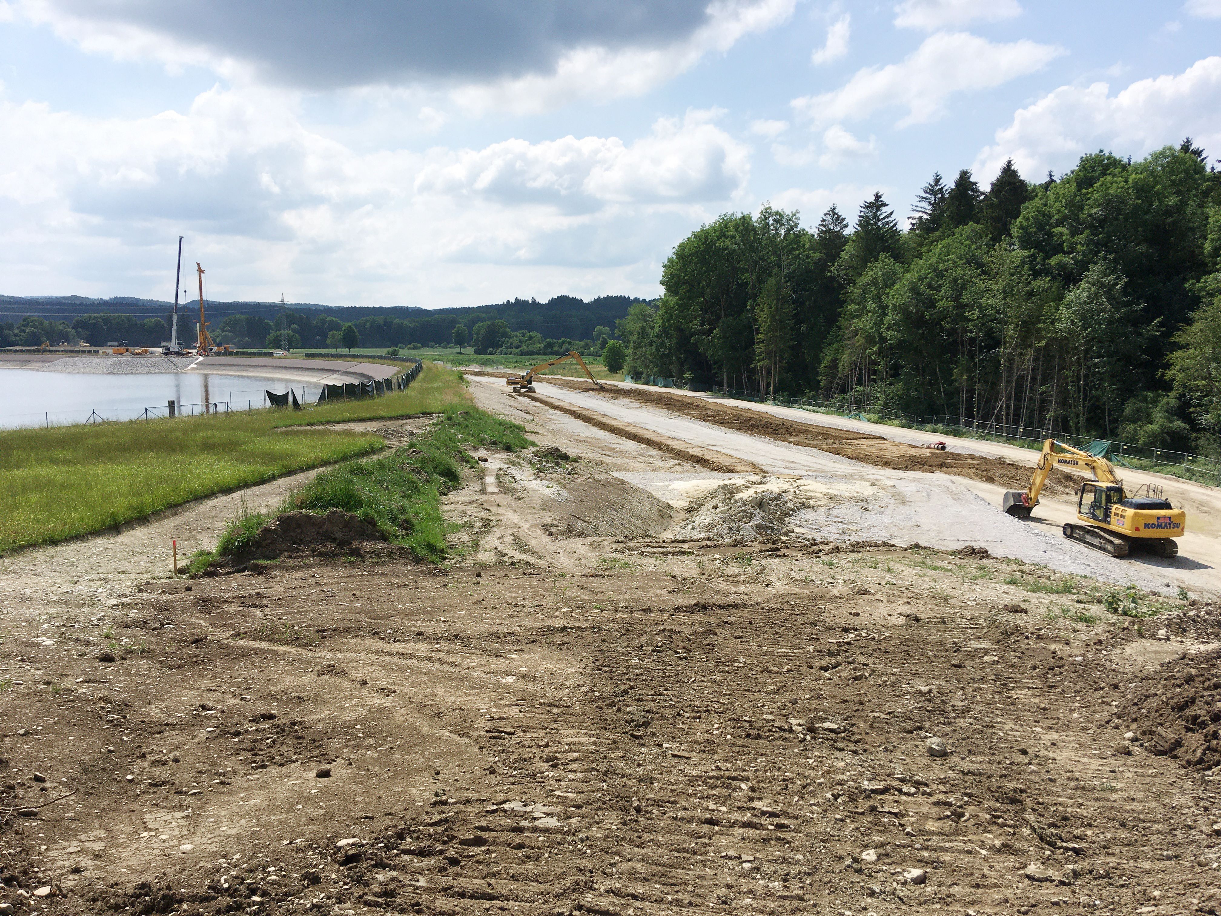 Abdeckung Untergrundabdichtung Absperrdamm, im Hintergrund Bohrpfahlwand für Überlaufbauwerk
