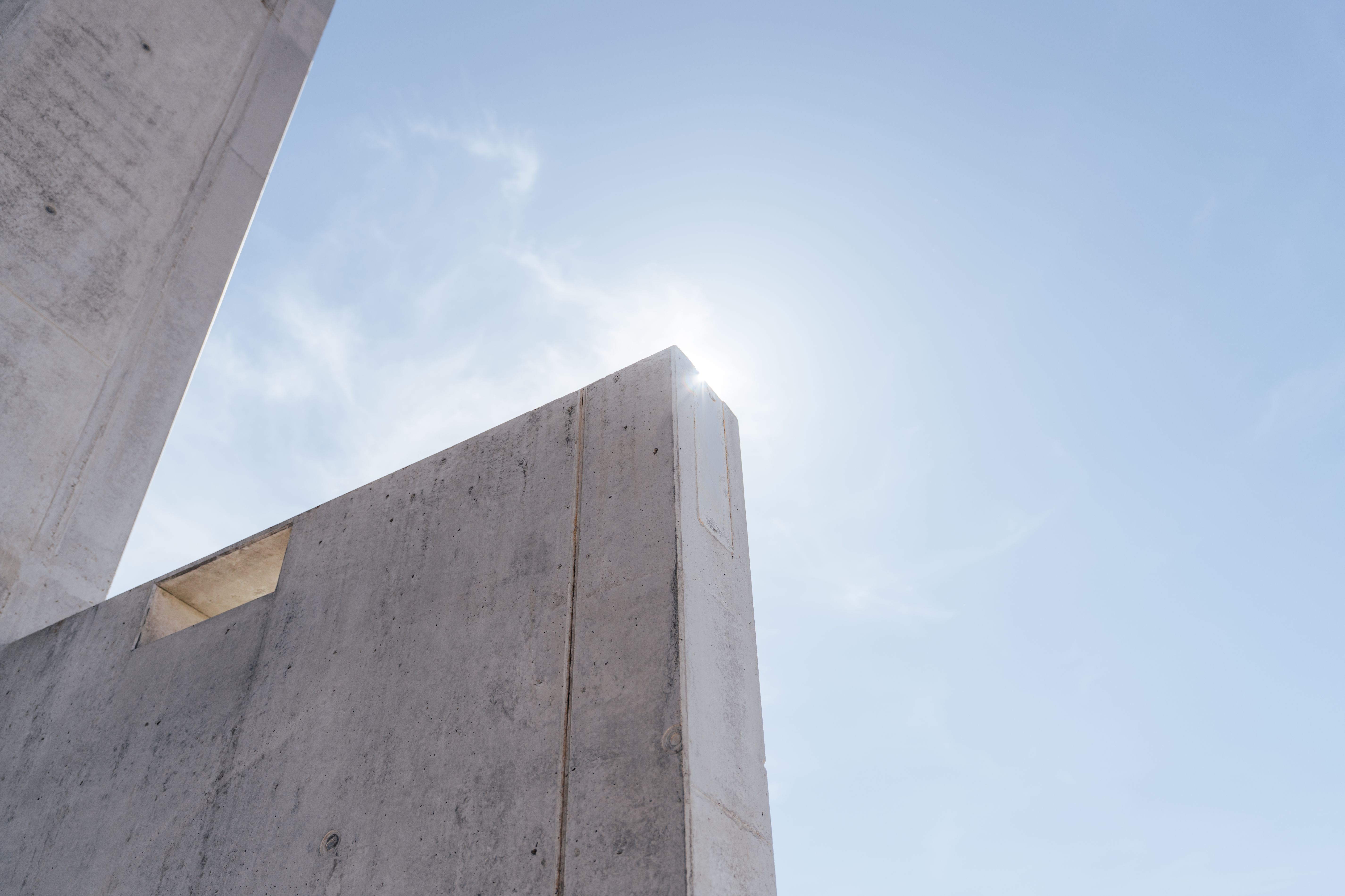 Hinter der Betonwand steigt langsam die Sonne auf