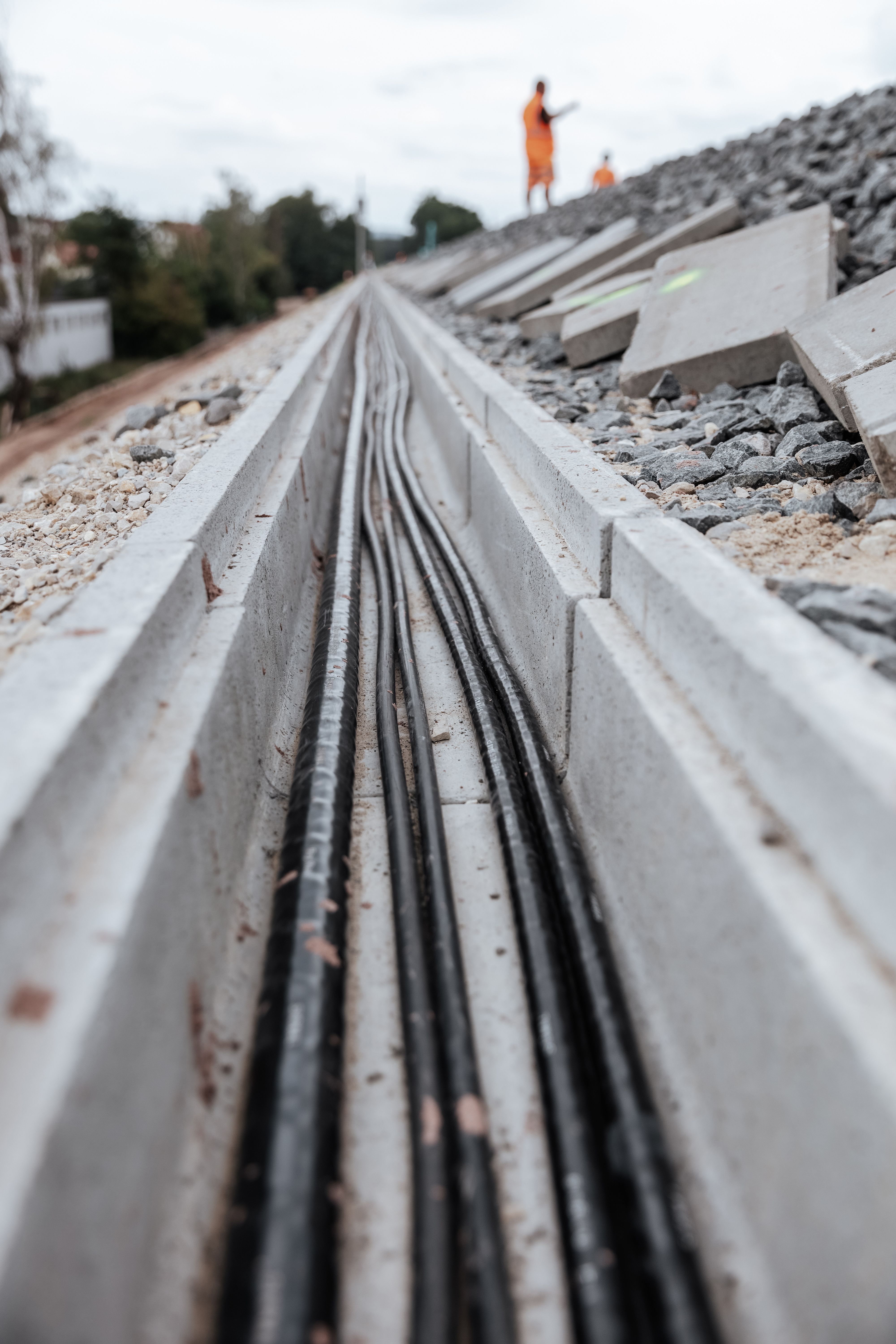 Detailaufnahme eines Kabelkanals, der neben einer Bahnstrecke verläuft